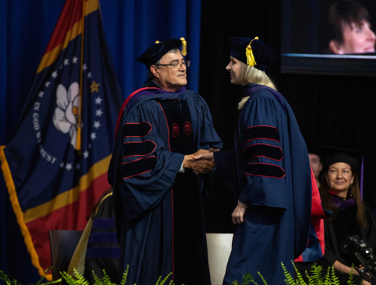 staff member and student at graduation