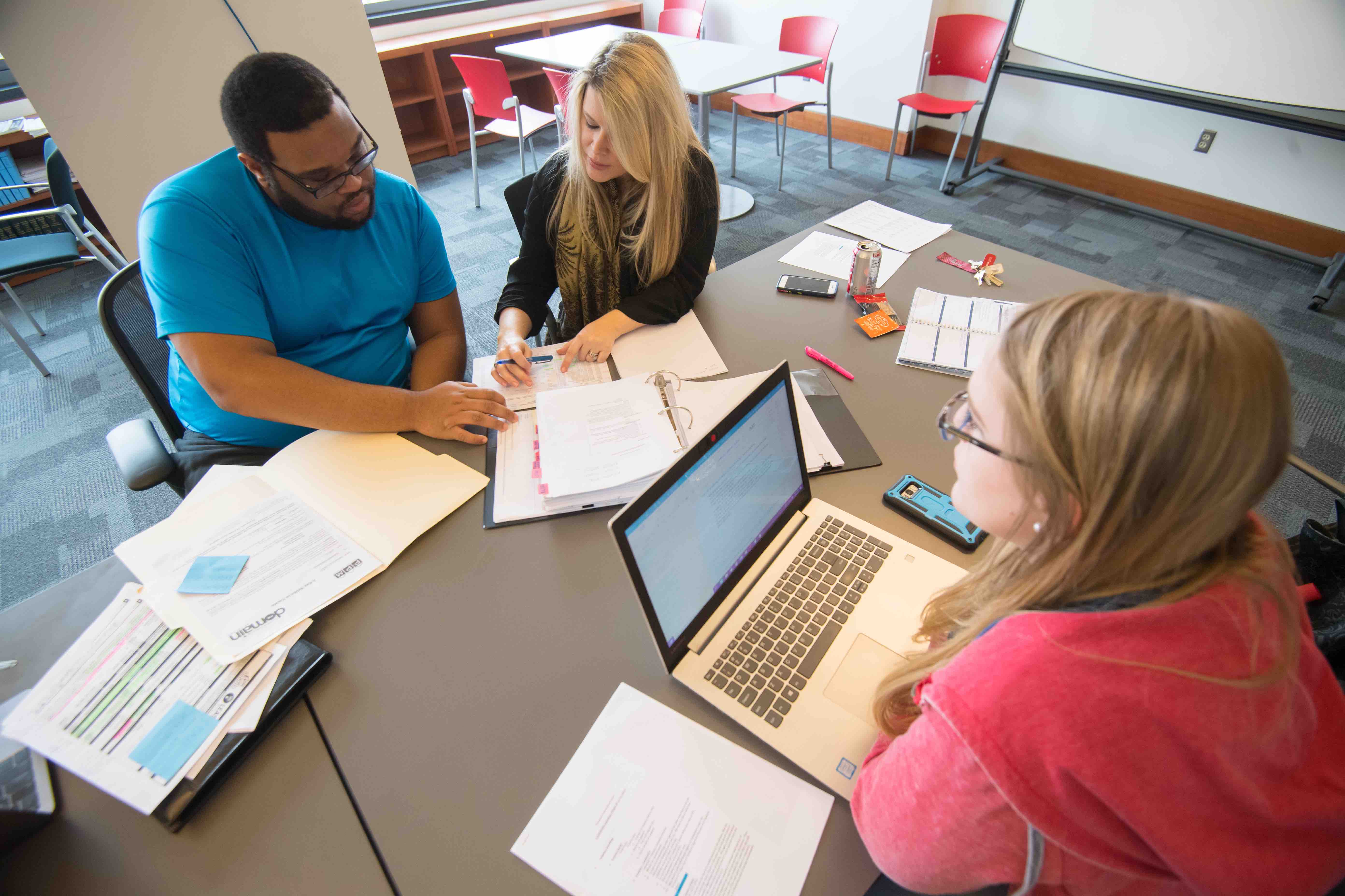 students and faculty in the housing clinic at a table