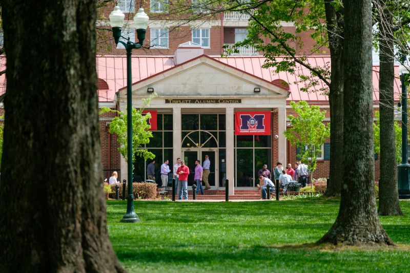 Alums Standing in front of Lamar Order Wall