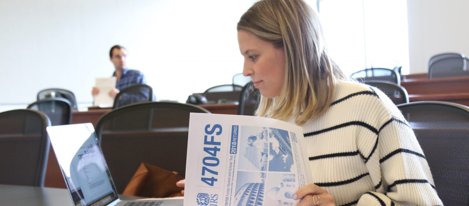 A law student enrolled in the tax clinic looks through tax forms to prepare for class.