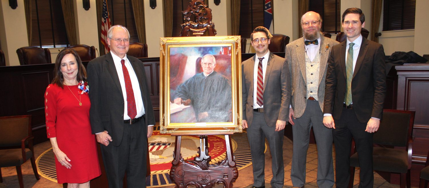 Former MS Supreme Court Chief Justice Bill Waller and his family stand with his painted portrait in the Supreme Court building.